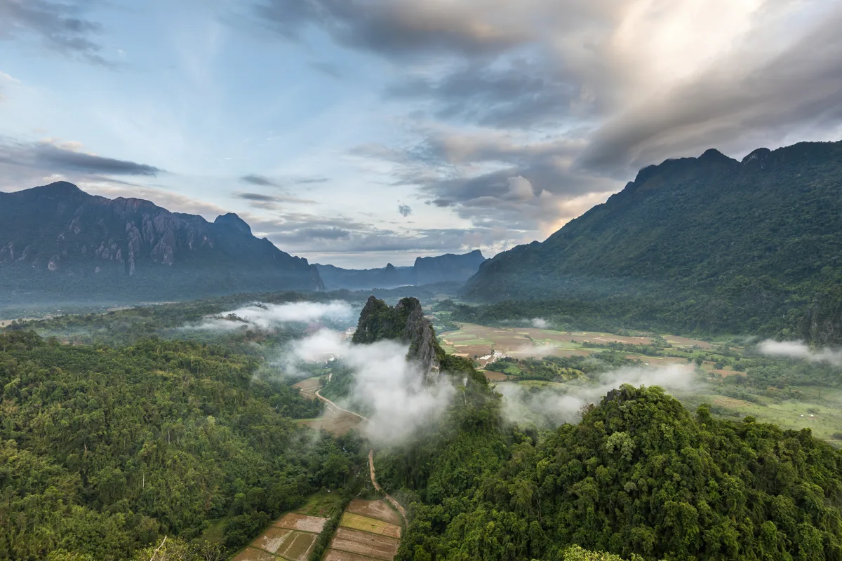 Sunrise panorama over dramatic karst peaks and morning mist from the summit of Mount Nam Xay